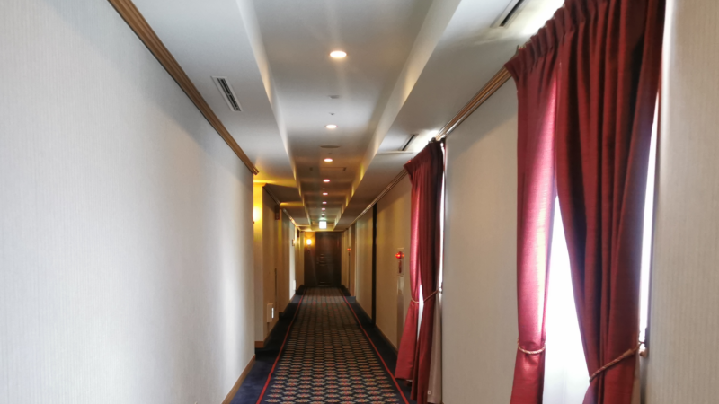 ホテルの廊下。赤いカーテンがある。