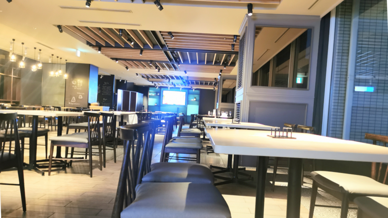 レストランの店内。白いテーブルと黒い椅子。